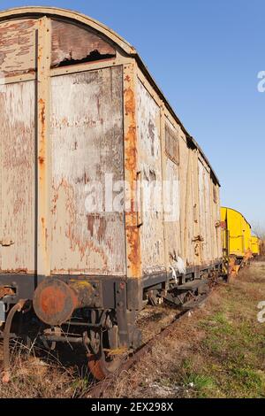 Old abandoned weathered and rusty train cargo wagon on an old train tracks Stock Photo