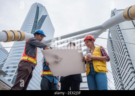 Team of engineer with businessman holding blueprint meeting and discussing for a new project in construction site at urban Stock Photo