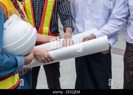 Team of engineer with myanmar businessman holding blueprint meeting and discussing of construction project at the city Stock Photo