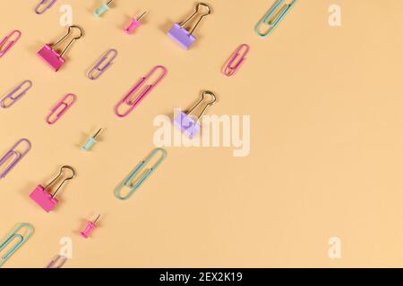 Stationery items like paper clips and drawing pins arranged on side of yellow background with empty copy space Stock Photo