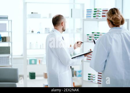 woman and a man are pharmacists discussing new medicines . Stock Photo
