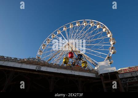 Big wheel, Blackpool Central Pier. Viewed from the beach below with clear blue sky. Stock Photo