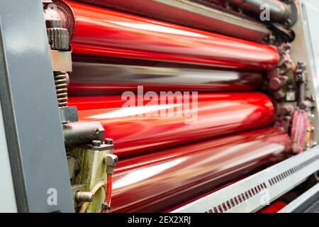 Color and glossy rollers of offset printing machine. offset ink colour.  Magenta Stock Photo