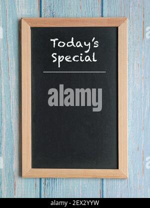 Today's Specials - words in white chalk on a blackboard isolated on blue wood. Copy space. Stock Photo