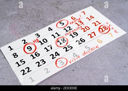 Plan a work week. Circle and strike through calendar dates. Write with a red felt-tip pen. Planning visit doctor, meeting, party birth day. Stock Photo