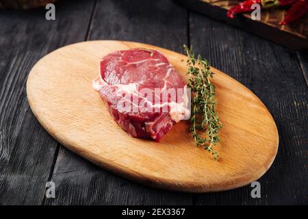 Side view on raw piece of meat with rosemary Stock Photo
