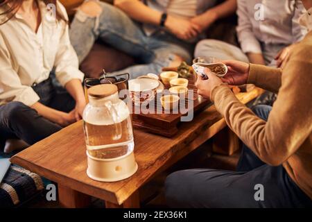 Group of friends sitting at the table with hot drinks in tea house Stock Photo
