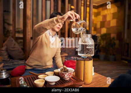 Handsome young man performing tea ceremony in cafe Stock Photo