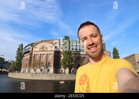 Seflie with parliament building in Stockholm city in Sweden. Adult male tourist self portrait. Stock Photo