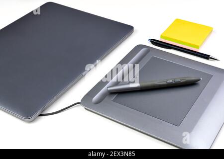 Closeup of a graphic tablet and pen on the designer's desk. Selective focus. Stock Photo
