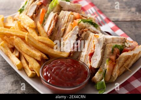 Club sandwich and French fries with ketchup sauce on wooden table Stock Photo