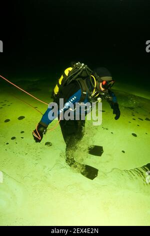 Scuba diver under ice walking upside down, exercise to practice orientation, Arctic circle Dive Center, White Sea, Karelia, northern Russia Stock Photo