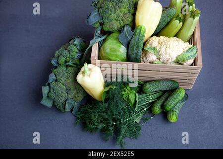 Vegetable basket. Fresh vegetables on the table black background. Set of food delivery box. Broccoli, cabbage, eggplant, white cabbage, cucumber, dill, cauliflower. Stilllife top view Stock Photo