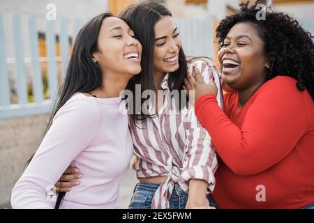 Happy latin girls enjoy time together outdoor around city - Friendship and diverse ethnicity concept - Main focus on black woman face Stock Photo