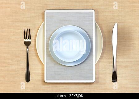 Serving for one person: a plate with a fork and a knife. On top of the tablet to order food online without contact, with photos on screen of additional plates. Stock Photo