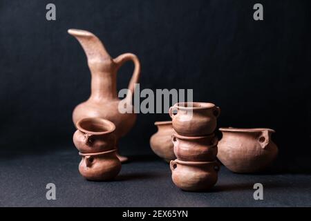 clay pots small mud vessel still life isolated on chiaroscuro black background Stock Photo