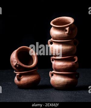 clay pots small mud vessel still life isolated chiaroscuro black background Stock Photo