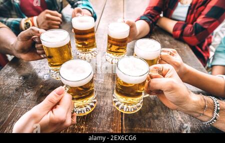 Friends hands toasting beer pints at brewery pub restaurant - Beverage concept with young people enjoying time together and having fun Stock Photo