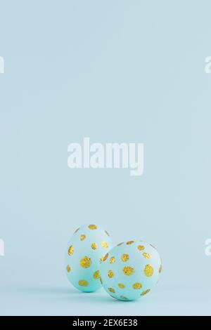 Festive easter background - blue easter eggs with golden glitter dots, vertical, copy space. Stock Photo