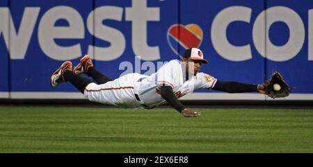 Baltimore Orioles center fielder Adam Jones (10), and Cesar Izturis (3)  celebrate with relief pitcher Mike Gonzalez (51) after the Orioles defeated  the Tampa Bay Rays 5-0 during a baseball game Friday