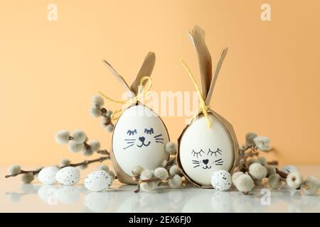 Easter bunnies made of eggs, quail eggs and catkins against beige background Stock Photo