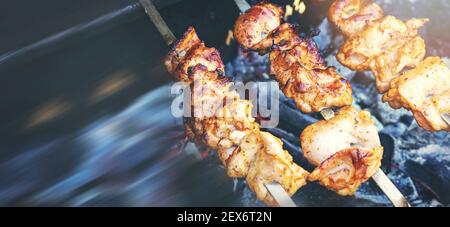 skewers with chicken meat grilling on a charcoal grill. copy space Stock Photo