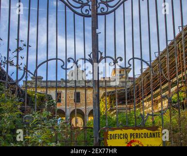 sign with warning of danger on the gate of an old abandoned factory Stock Photo