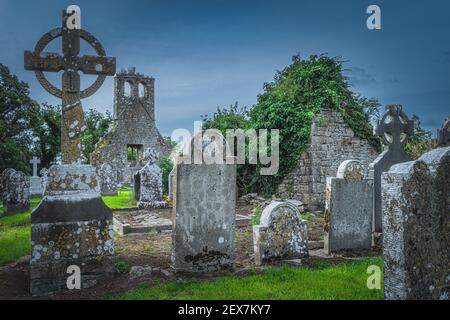 Small ancient cemetery and ruined church tower. Celtic style gravestones. Graveyard in Retaine, County Meath, Ireland Stock Photo