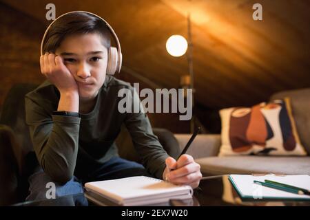 Little boy wearing headphones during online education course, lesson, view of screen. Using headphones. Easy, comfortable usage concept, education, online, childhood, modern technologies for remotion. Stock Photo