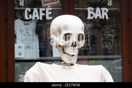 04 March 2021, Lower Saxony, Hanover: A skeleton sits outside a restaurant closed due to the Corona pandemic in Südstadt. The lockdown in Germany is extended until March 28. Photo: Julian Stratenschulte/dpa Stock Photo