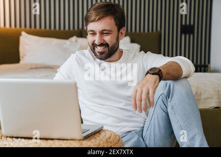 Smiling handsome man using laptop coputer at home Stock Photo
