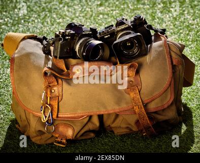 Two Olympus 35 mm film single lens reflex cameras sitting on a Billingham 550 camera bag Stock Photo