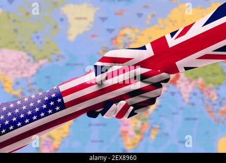 Diplomatic handshake between countries: flags of United States and United Kingdom overprinted the two hands Stock Photo