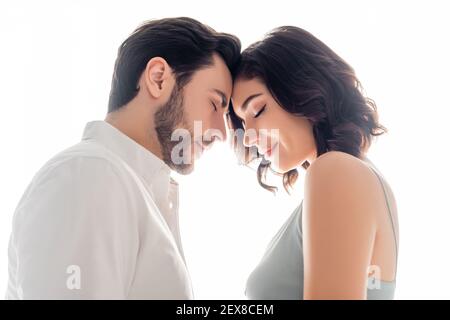 Side view of man standing with closed eyes near wife isolated on white Stock Photo