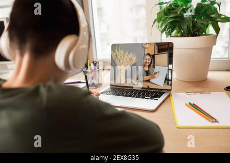 Little boy studying by group video call, use video conference with teacher, listening to online course. Using headphones, notebook. Easy, comfortable usage concept, education, online, childhood. Stock Photo