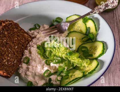 Salad with cottage cheese and cucumber served on a plate with bread Stock Photo