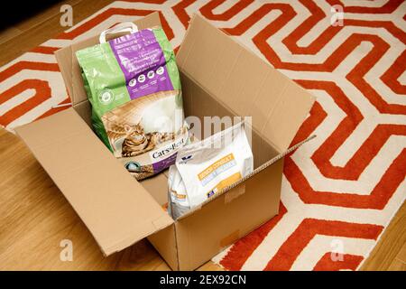 Strasbourg, France - Jan 16, 2021: Living room carpet with cardboard box delivery containing Cats Best litter wood bio organic and Royal Canin Senior Consult stage cat's food Stock Photo