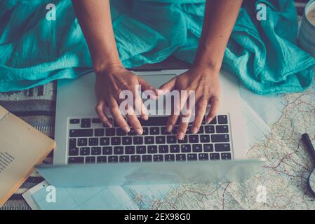 Top view of caucasian woman hands search the web using notebook laptop to plan next travel destination vacation holidays at home - happy people work w Stock Photo