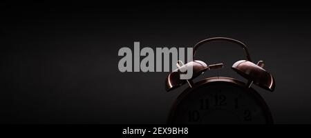 Retro alarm clock on dark background with subtle lighting Stock Photo
