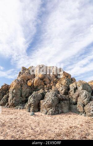 Volcanic rock outcrop at Llanddwyn Island, Newborough Beach, Anglesey, North Wales Stock Photo