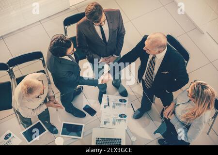 top view. financial partners confirming the transaction with a handshake. Stock Photo