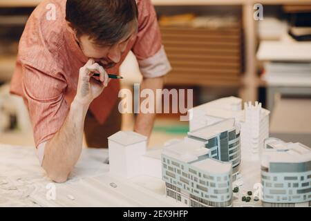Architect Thoughtful with blueprints and layout design project at office bureau Stock Photo