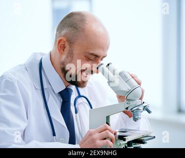researcher looking through a microscope in a medical laboratory. Stock Photo