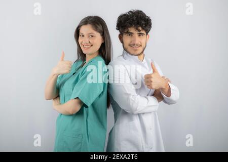 Happy medical workers making hand gesture thumbs up Stock Photo