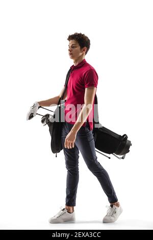 Posing with equipment. Golf player in a red shirt isolated on white studio background with copyspace. Professional player practicing with emotions and facial expression. Sport, motion, action concept. Stock Photo