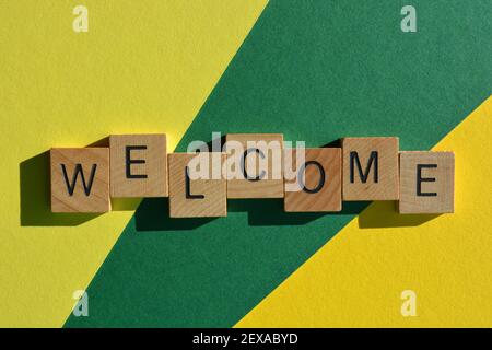 Welcome, word in wooden alphabet letters isolated on yellow and green background Stock Photo