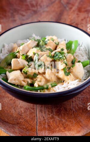 Thai pineapple curry with diced chicken and sliced peas over coconut rice Stock Photo