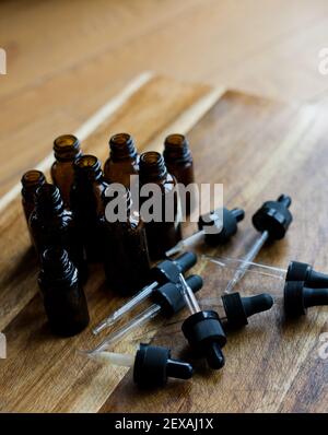 A Collection of Amber Dropper Bottles on a Wooden Background Stock Photo