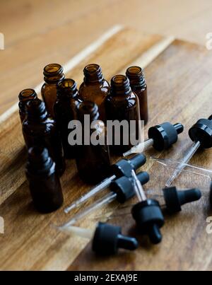 A Collection of Amber Dropper Bottles on a Wooden Background Stock Photo