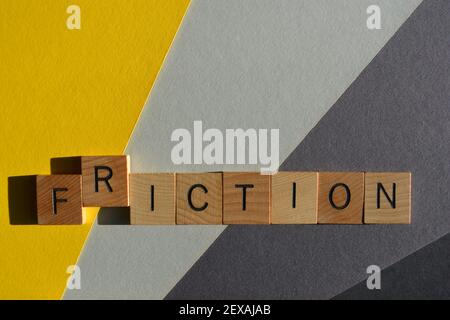 Friction, Fiction, word in wooden alphabet letters isolated on grey and yellow background with copy space Stock Photo